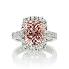 a pink diamond ring with diamonds around it