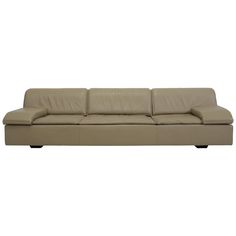 a beige leather couch with black legs