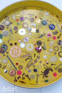 a yellow tray filled with lots of different types of buttons and other things on it