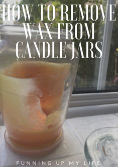 a glass filled with liquid sitting on top of a window sill