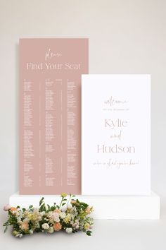 a wedding seating chart with flowers and greenery next to it on a white pedestal