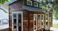 the tiny house is made out of wood and has windows