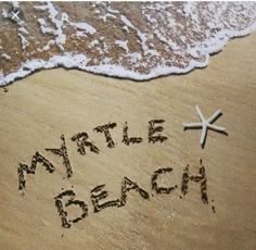 a starfish is on the beach with words written in sand next to the water