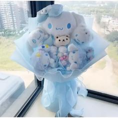 a bunch of stuffed animals sitting in a bouquet on a window sill near a window