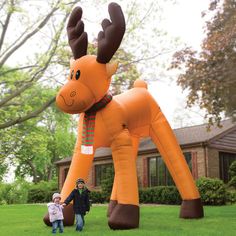 an inflatable moose and child standing next to it's mother on the lawn