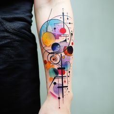 a woman's arm with colorful abstract tattoos on it, including circles and lines