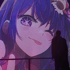 a person standing in front of a screen with an anime character on it's face