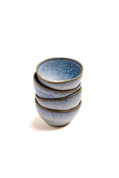 four blue bowls stacked on top of each other in front of a white background,