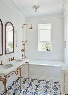 a bathroom with two sinks and a bathtub next to a window in the corner