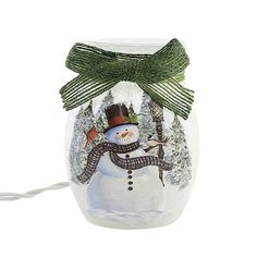 a glass jar with a snowman on the inside and green ribbon around it's neck