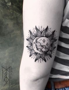 a sun and moon tattoo on the left upper half of the arm is black and white