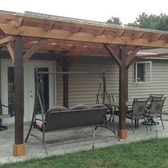 a covered patio with chairs and tables in front of a house on a sunny day