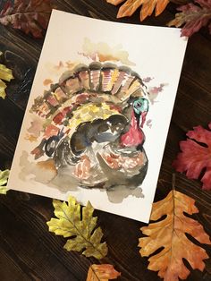 a watercolor painting of a turkey with autumn leaves around it on a wooden table