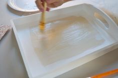 a person is painting on a white tray