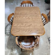 a wooden table with chairs around it in a garage area, surrounded by other wood furniture