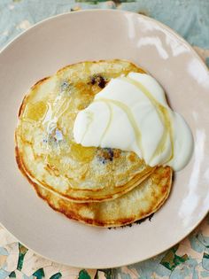 two pancakes on a plate topped with whipped cream