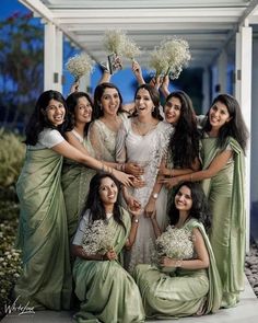 a group of women standing next to each other holding bouquets in front of them