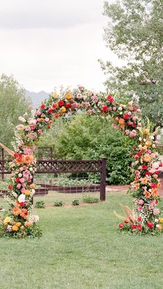 an outdoor ceremony setup with flowers and greenery