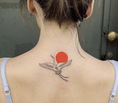 a woman with a red sun behind her back tattoo on her left shoulder and neck