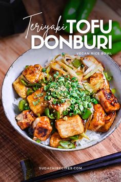 a bowl filled with tofu and vegetables next to chopsticks