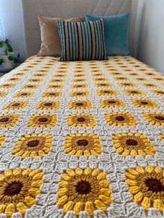 a crocheted bedspread with sunflowers on it and two pillows