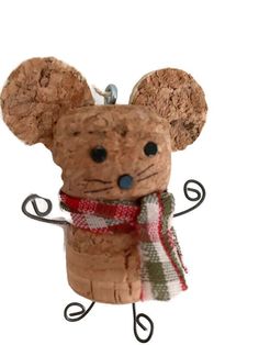 a cork mouse ornament with a scarf around it's neck and ears