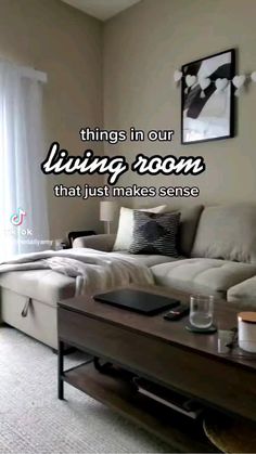 a living room with a couch, coffee table and pictures on the wall above it