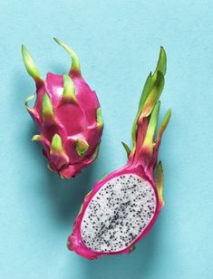 two dragon fruit cut in half on a blue background