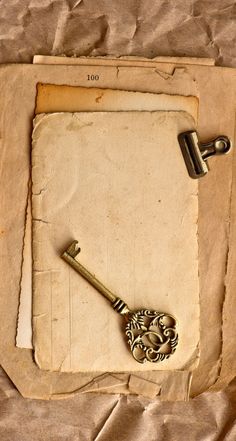 an old key laying on top of a piece of paper