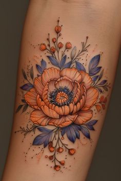 an orange and blue flower on the side of a woman's leg