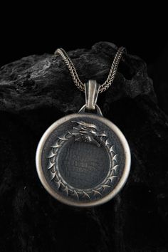 This Ouroboros dragon snake ring necklace is stylish and pretty ideal for everyday use. The engraving details of the 925k handmade silver pendant are very detailed and eye-catching. The jewelry is coated with oxide to emphasize the details of handmade engraving The best colors are Oxidized-Rose-Yellow and Rhodium Color on this product you can see all details clearly. You can find Product colors variations shown as representative on  image. Made from high-quality sterling silver, this ouroboros n Symbolic Engraved Snake Chain Jewelry, Sterling Silver Necklace With Dragon Design, Spiritual Snake-shaped Engraved Jewelry, Sterling Silver Jewelry With Dragon Design Round Pendant, Snake-shaped Engraved Jewelry Gift, Spiritual Engraved Snake Jewelry, Engraved Snake-shaped Jewelry Gift, Silver Dragon Design Round Pendant Jewelry, Silver Snake-shaped Oxidized Jewelry