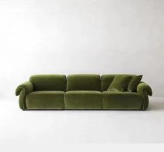 a green couch sitting on top of a white floor