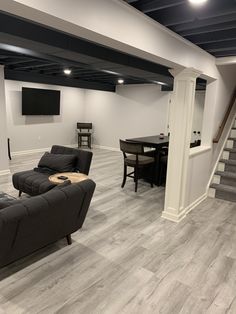 a living room filled with furniture and a flat screen tv mounted to the wall above it