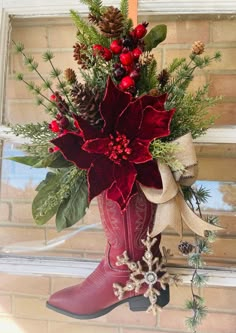 a red boot with christmas decorations hanging from it's side on a window sill