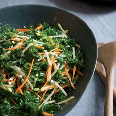 a salad with carrots, parmesan cheese and lettuce in a bowl