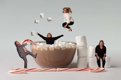 three people are jumping in a bowl of marshmallows and candy canes