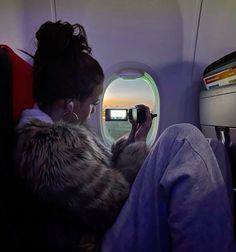 a woman sitting on an airplane looking out the window