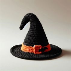 a crocheted witch hat with an orange stripe on the front and black brim