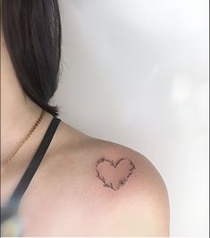 a woman with a heart tattoo on her shoulder