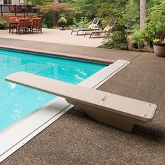 an empty pool with a bench next to it in the middle of a patio area