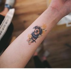 a small dog tattoo on the left arm and wrist is shown in this image, it appears to be inked onto someone's right arm