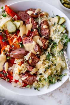 a white bowl filled with meat and vegetables