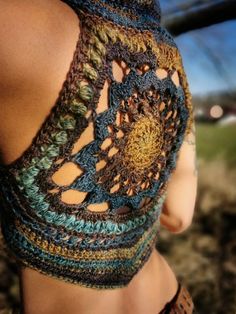 the back of a woman's top that has crocheted designs on it