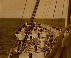 people are standing on the deck of a ship