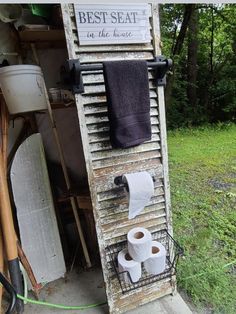 two rolls of toilet paper sitting on top of a wooden rack next to an old door