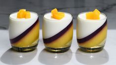 three glasses filled with fruit sitting on top of a white counter next to each other