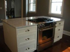 a kitchen with an oven, stove and counter top in the middle of the room