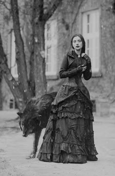 a black and white photo of a woman in a dress with a dog on her lap