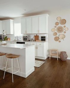 a kitchen with white cabinets and wooden floors