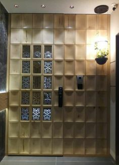 an elevator with wooden paneling and decorative glass blocks on the wall, along with a planter